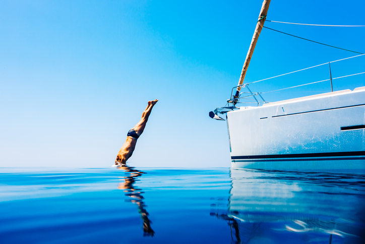 man diving into ocean from yacht charter